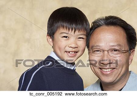Stock Image - Asian father and young son smiling. Fotosearch