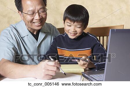 Asian father helping young son with homework View Large Photo Image Stock Photograph - Asian father helping young son with homework. Fotosearch