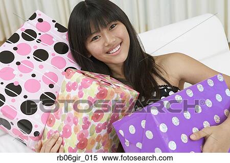 Asian girl holding gifts View Large Photo Image Stock Photography - Asian girl holding gifts. Fotosearch