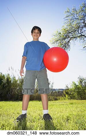 Stock Photo - Boy with ball in bright sunlight. Fotosearch