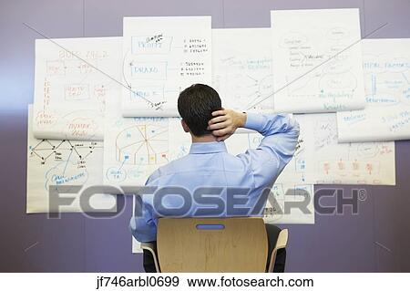 Businessman looking at wall charts View Large Photo Image Stock Photo - Businessman looking at wall charts. Fotosearch
