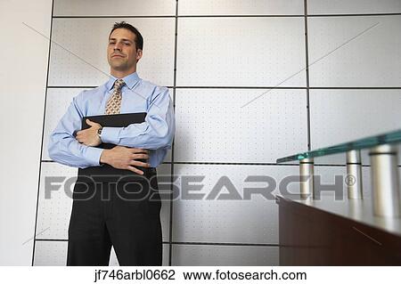 Businessman standing in front of wall View Large Photo Image Stock Image - Businessman standing in front of wall. Fotosearch