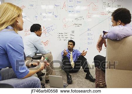 Businesspeople having a meeting in front of a whiteboard wall View Large Photo Image Stock Photo - Businesspeople having a meeting in front of a whiteboard wall. Fotosearch