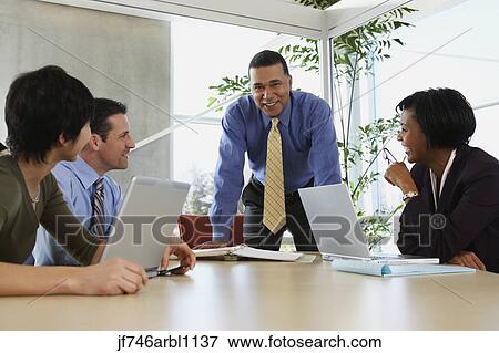 Stock Photo - Businesspeople having a meeting. Fotosearch