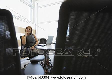 Picture - Businesswoman at desk in office. Fotosearch