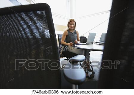 Stock Photograph - Businesswoman at desk in office. Fotosearch