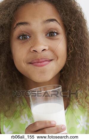 Stock Photography - Close up of African American girl drinking milk. Fotosearch