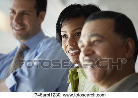 Stock Image - Close up of businesspeople smiling. Fotosearch
