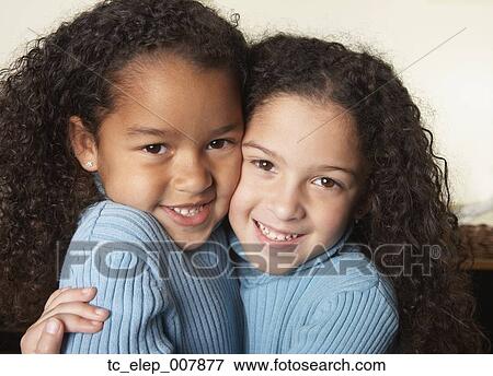 Stock Photo - Close up of two young girls hugging. Fotosearch