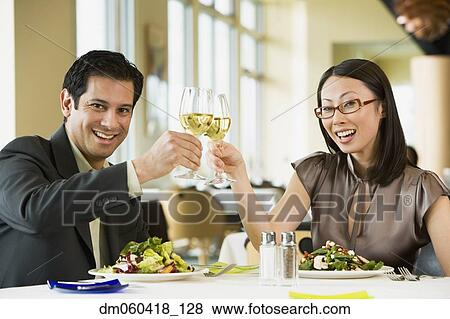 Couple toasting at restaurant View Large Photo Image Stock Photo - Couple toasting at restaurant. Fotosearch