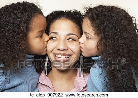 Stock Image - Girls kissing mother on cheek. Fotosearch