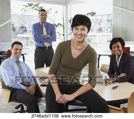 Group of businesspeople smiling in office View Large Photo Image Stock Photo - Group of businesspeople smiling in office. Fotosearch