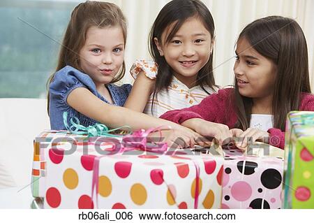 Group of young girls opening gifts View Large Photo Image Stock Photograph - Group of young girls opening gifts. Fotosearch