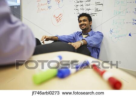 Stock Image - Indian businessman in front of white board in office. Fotosearch