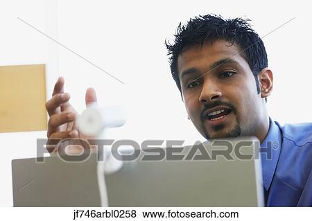 Stock Photo - Indian businessman using webcam. Fotosearch