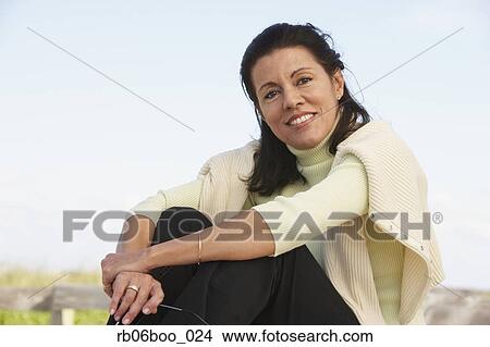 Middle-aged woman sitting outdoors View Large Photo Image Picture - Middle-aged woman sitting outdoors. Fotosearch