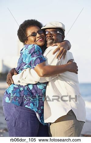 Stock Photography - Senior African American couple hugging outdoors. Fotosearch
