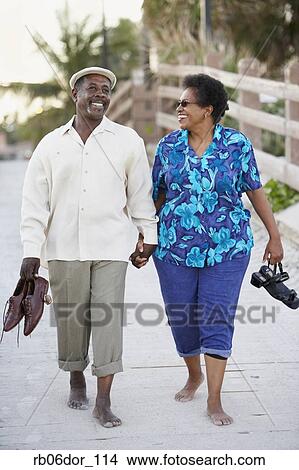 Senior African American couple walking on boardwalk View Large Photo Image Picture - Senior African American couple walking on boardwalk. Fotosearch