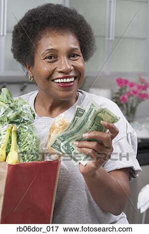 Senior African American woman with money and groceries View Large Photo Image Stock Photo - Senior African American woman with money and groceries. Fotosearch