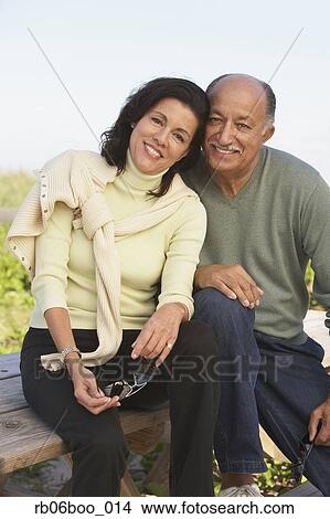 Picture - Senior couple hugging and smiling outdoors. Fotosearch