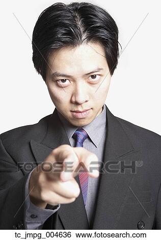 Studio shot of Asian businessman pointing finger View Large Photo Image Stock Photograph - Studio shot of Asian businessman pointing finger. Fotosearch