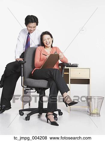 Stock Photo - Studio shot of Asian businesspeople laughing. Fotosearch