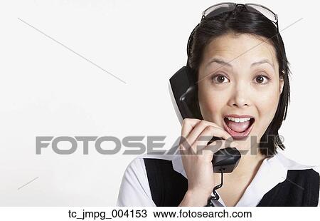 Stock Image - Studio shot of Asian businesswoman talking on telephone. Fotosearch