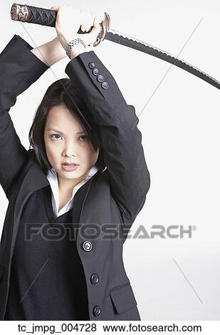 Studio shot of Asian businesswoman holding sword View Large Photo Image Stock Photo - Studio shot of Asian businesswoman holding sword. Fotosearch