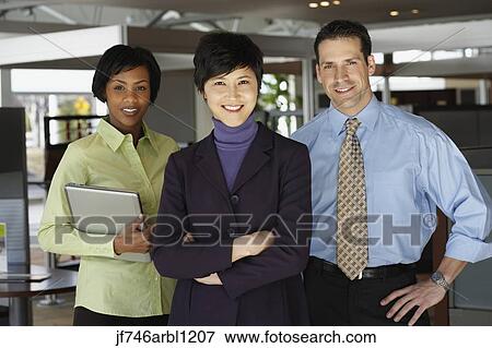 Three businesspeople in office smiling View Large Photo Image Stock Photo - Three businesspeople in office smiling. Fotosearch