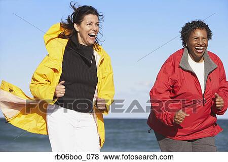 Stock Photo - Two middle-aged women laughing outdoors. Fotosearch