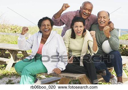 Stock Image - Two senior couples cheering outdoors. Fotosearch