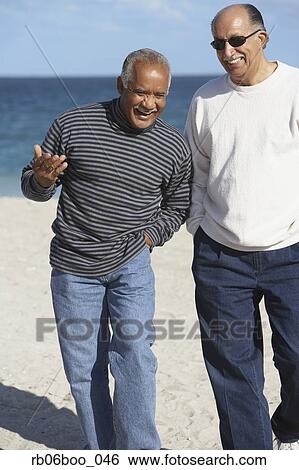 Two senior men talking on beach View Large Photo Image Stock Photograph - Two senior men talking on beach. Fotosearch