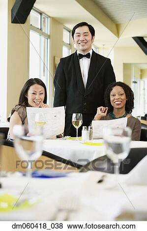 Two women with waiter in restaurant View Large Photo Image Stock Photo - Two women with waiter in restaurant. Fotosearch
