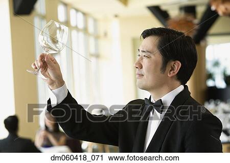 Upscale male waiter examining glass View Large Photo Image Stock Image - Upscale male waiter examining glass . Fotosearch