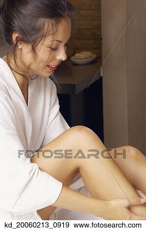 Woman in bathrobe applying lotion View Large Photo Image Stock Photo - Woman in bathrobe applying lotion. Fotosearch