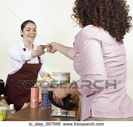 Stock Photo - Woman paying for groceries. Fotosearch