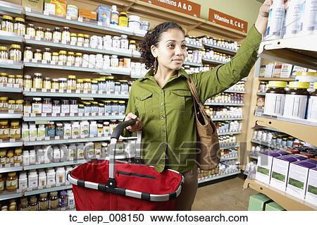 Stock Image - Woman shopping for vitamins. Fotosearch