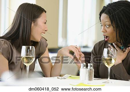 Woman showing friend engagement ring at restaurant View Large Photo Image Stock Image - Woman showing friend engagement ring at restaurant. Fotosearch