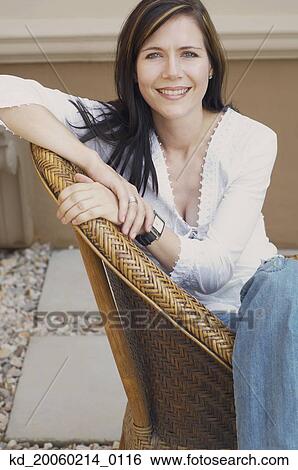 Woman sitting in chair smiling View Large Photo Image Stock Photograph - Woman sitting in chair smiling. Fotosearch