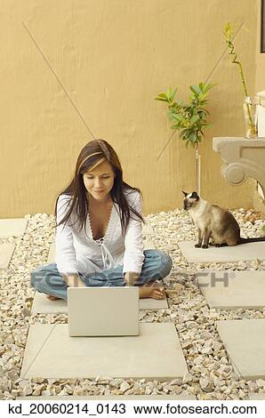Stock Image - Woman with laptop and cat outdoors. Fotosearch