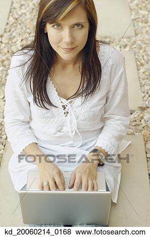 Stock Photo - Woman working on laptop outdoors. Fotosearch