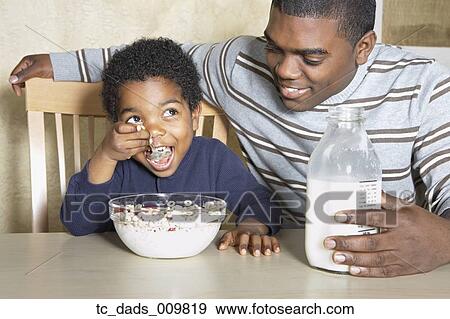 Young African American boy eating cereal with father View Large Photo Image Stock Photo - Young African American boy eating cereal with father. Fotosearch