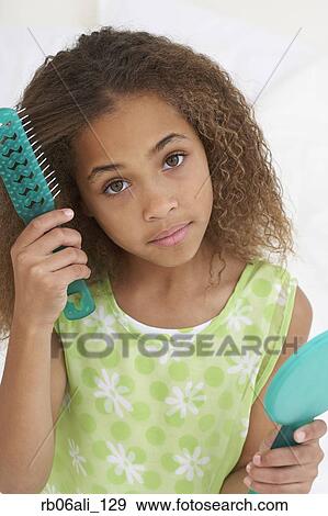 Stock Photo - Young African American girl brushing hair. Fotosearch