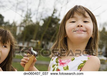Young Asian girl eating ice cream cone View Large Photo Image Stock Photo - Young Asian girl eating ice cream cone. Fotosearch