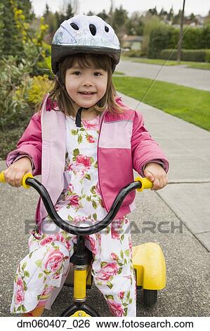 Young Asian girl with helmet riding tricycle View Large Photo Image Stock Photograph - Young Asian girl with helmet riding tricycle. Fotosearch