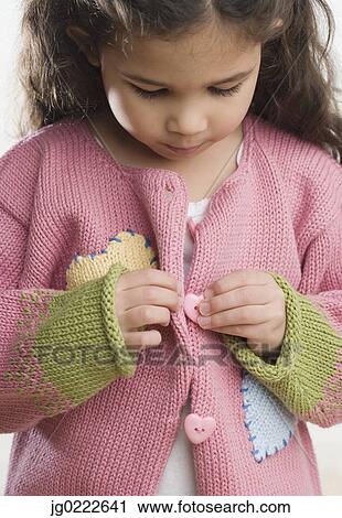 Young Hispanic girl buttoning sweater View Large Photo Image Stock Image - Young Hispanic girl buttoning sweater. Fotosearch