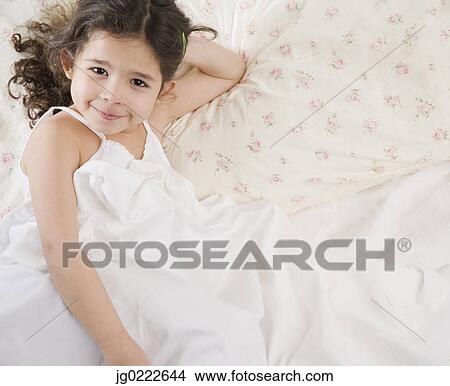 Picture - Young Hispanic girl in bed. Fotosearch