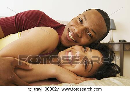 Stock Photo - African couple hugging on bed. Fotosearch