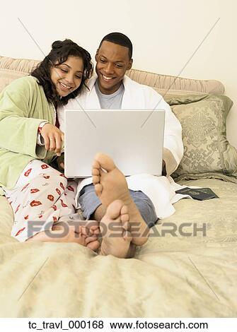African couple in pajamas using laptop in bed View Large Photo Image Stock Photo - African couple in pajamas using laptop in bed. Fotosearch