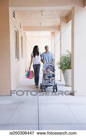 Stock Photo - African couple pushing baby in stroller. Fotosearch